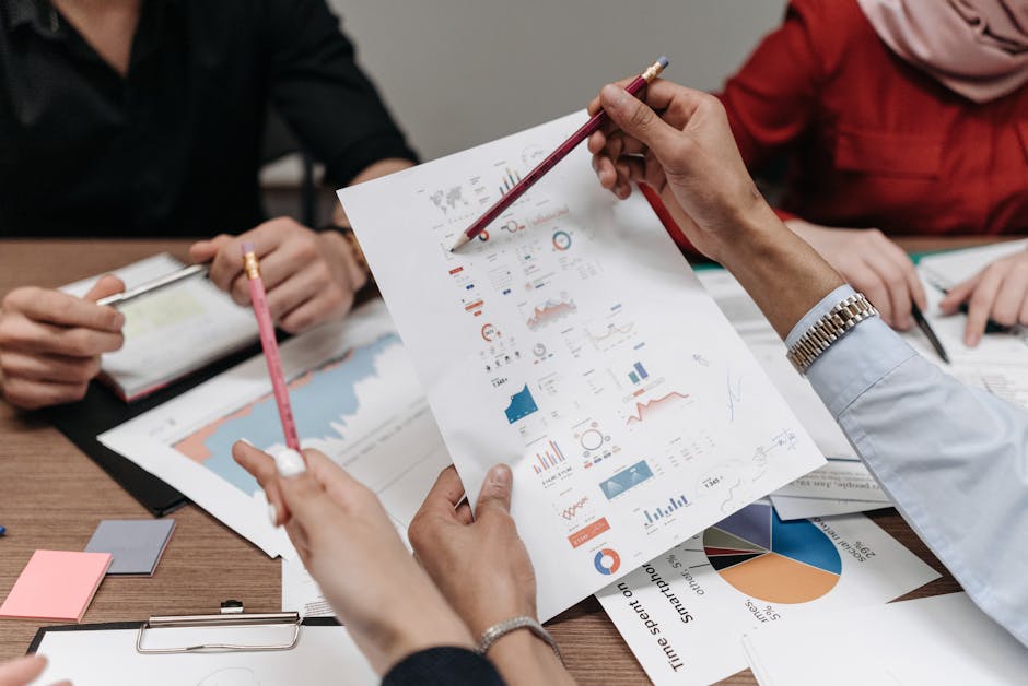 Team analyzing business reports and charts during a collaborative meeting.