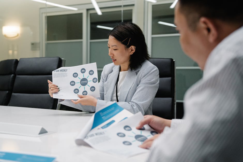 Colleagues in a modern conference room analyzing business reports and strategies during a meeting.